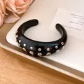 Macro view of stylish black resin cuff bracelet featuring silver metal rivet studs - Bangle / Black
