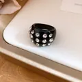 Detailed view of a stylish black resin ring inlaid with sparkling clear round rhinestones - Ring / Black