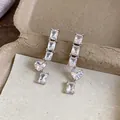 Close-up of elegant silver earrings with sparkling square and heart-shaped zircon stones. - Silver Needle Square Heart Drop Style / Silver