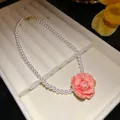 Detail shot of the intricate pink resin rose pendant on a lustrous pearl necklace - Necklace-Pink-White