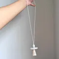 Dettaglio di una collana lunga con pendente geometrico irregolare in pietra color pesca. - Collana-Bianco