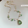 Macro detail of retro gold-tone necklace with emerald green crystals and elegant pearls. - Necklace (HN11401) / Gold with Green