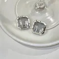 Exquisite close-up of minimalist square grey glass stud earrings with silver-toned settings - Square Glass Style / Silver