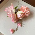 Détail rapproché des élégantes fleurs en tissu rose et des glands en perles du clip. - Pinces à cheveux bec de canard / Pièce Unique / Rose