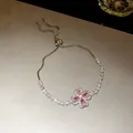 Close-up detail of a sparkling pink zircon clover bracelet with adjustable drawstring closure - Clover Bolo Bracelet / Silver/Pink