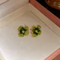 Detailed macro view of elegant flower stud earrings with green gradient crystals. - Tops / Green