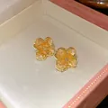 Detailed view of gold flower stud earrings with amber crushed stone inlay in a gift box - Tops / Yellow
