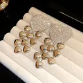 Close-up of sparkling rhinestone heart earrings with cascading silver heart tassels - Heart Tassel Style (HE32644) / Silver