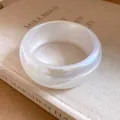 Détail d'un bracelet large en résine blanche translucide avec des reflets irisés - Blanc