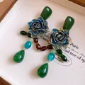 Close-up of vintage style blue resin rose earrings featuring colorful crystal drop pendants - Silver Earring Post-Green