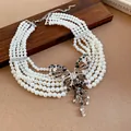 Detail einer Vintage mehrsträngigen Perlenkette mit Strass Schmetterling - Weiß