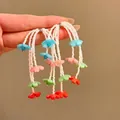 Detailed view of colorful handmade flower beaded tassel earrings with white seed beads. - Tassel Studs / Colorful