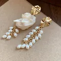 Detailed close-up of French vintage gold pearl tassel earrings with seashell accent - Asymmetrical Conch Pearl Tassel Style / Gold with White