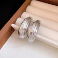Dettaglio di orecchini a goccia color argento con elegante trama metallica a coste - goccia / Argento