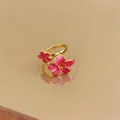 Vista dettagliata dell'anello a fiori in smalto rosa con elegante finitura dorata - Aperto Regolabile / Oro-Rosa Rosso