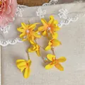 Detailed close-up of yellow fabric flower earrings featuring pearls and long tassels - Long Tassel Dangle Earrings / Yellow