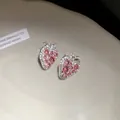 Close-up detail of sparkling pink strawberry stud earrings with rhinestones and silver pins - Pink