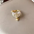 Exquisite detail of a gold-plated heart zircon ear cuff featuring a unique cross motif - Ear Bone Clip (Single) / Gold