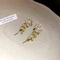 Close-up of elegant gold flower earrings with crystals and pearls. - Gold