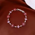Close-up detail of silver-toned metal bracelet with pink and red zircon flowers - Rose Red-Pink