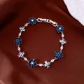 Close-up of elegant flower and cross bracelet with blue and white cubic zirconia stones - Deep Blue-Light Blue