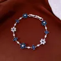 Detailed macro shot of an elegant silver bracelet with blue and white floral zircon stones - Silver-Blue