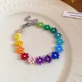 Macro view of a bohemian rainbow seed bead flower necklace featuring a silver lobster clasp - Bracelet / Colorful