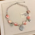 Detailed view of pink shell necklace with starfish and seashell silver charms - Pink
