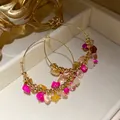Dettaglio di orecchini a cerchio dorati con pietre colorate in stile etnico retrò - Orecchini a Cerchio Rotondi con Perline di Pietra (HE33733) / Oro-Multicolore
