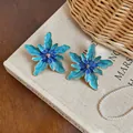 Detailed view of oversized blue gradient enamel flower earrings with gold edges - Gold Style / Blue