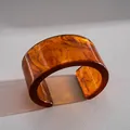 Gros plan détaillé d'un large bracelet en acrylique ambré avec texture écaille de tortue - Ambre