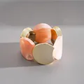 Vue détaillée montrant la texture marbrée de l'acrylique et des disques dorés du bracelet - Rose Or