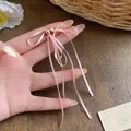 Vue détaillée des boucles d'oreilles à nœud en ruban rose avec aiguilles en argent - Style de Gland Long (HE32551) / Rose