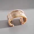 Détail d'un large bracelet manchette en acrylique avec texture marbre sur fond gris - Marbre Clair