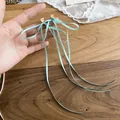 Boucles d'oreilles nœud en ruban bleu clair avec longues nappes, affichage SKU mains - Style de Gland Long (HE32551) / Bleu