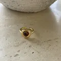 Close-up of a Maillard style gold ring with round resin stone on stone surface - Round Resin Open Ring / Gold Brown