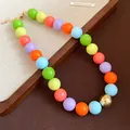 Close-up of colorful chunky bead necklace with vibrant resin pearls and gold clasp. - Necklace / Colorful