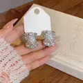 Detalle de pendientes de flor calada en plata con brillantes piedras de circonita - Plateado