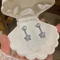 Detailed view of elegant silver-toned star zircon drop earrings in a white shell box - 925 Silver Needle / Silver