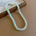 Close-up of handmade woven beaded necklace with mint green and clear crystal beads - Necklace / White-Green