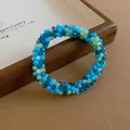 Detailed macro shot of the colorful faceted crystal beads in a braided jewelry design - Bracelet / Blue Green