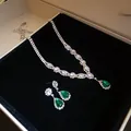 Detailed view of elegant silver necklace and drop earring set with emerald green stones - Silver-Green