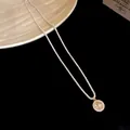 Detailed view of a silver-toned zircon necklace with a sparkling golden flower pendant - Gold-Silver