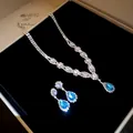 Detail of sparkling blue zircon teardrop pendant necklace and earring set in jewelry box. - Silver-Blue