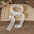 Close-up view of a delicate white floral lace ribbon scarf used as hair band or necktie - Hollow Flower (Style 2) / White