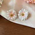 Vista dettagliata di orecchini a margherita in smalto bianco con petali glitterati e oro - Perno Argento Margherita / Bianco-Rosa
