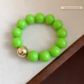 Exaggerated neon green large round bead bracelet with a single gold accent bead - Bracelet / Green