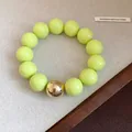 Oversized neon green beaded bracelet featuring a single gold metallic accent bead - Bracelet / Light Yellow