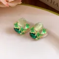 Macro detail of green enamel butterfly ear studs with translucent beads and gems - Green