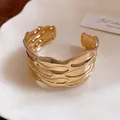 Detailed macro view of a vintage gold textured open cuff bracelet with elegant wavy patterns - 纹路条纹开口款式(HB5768) / Gold